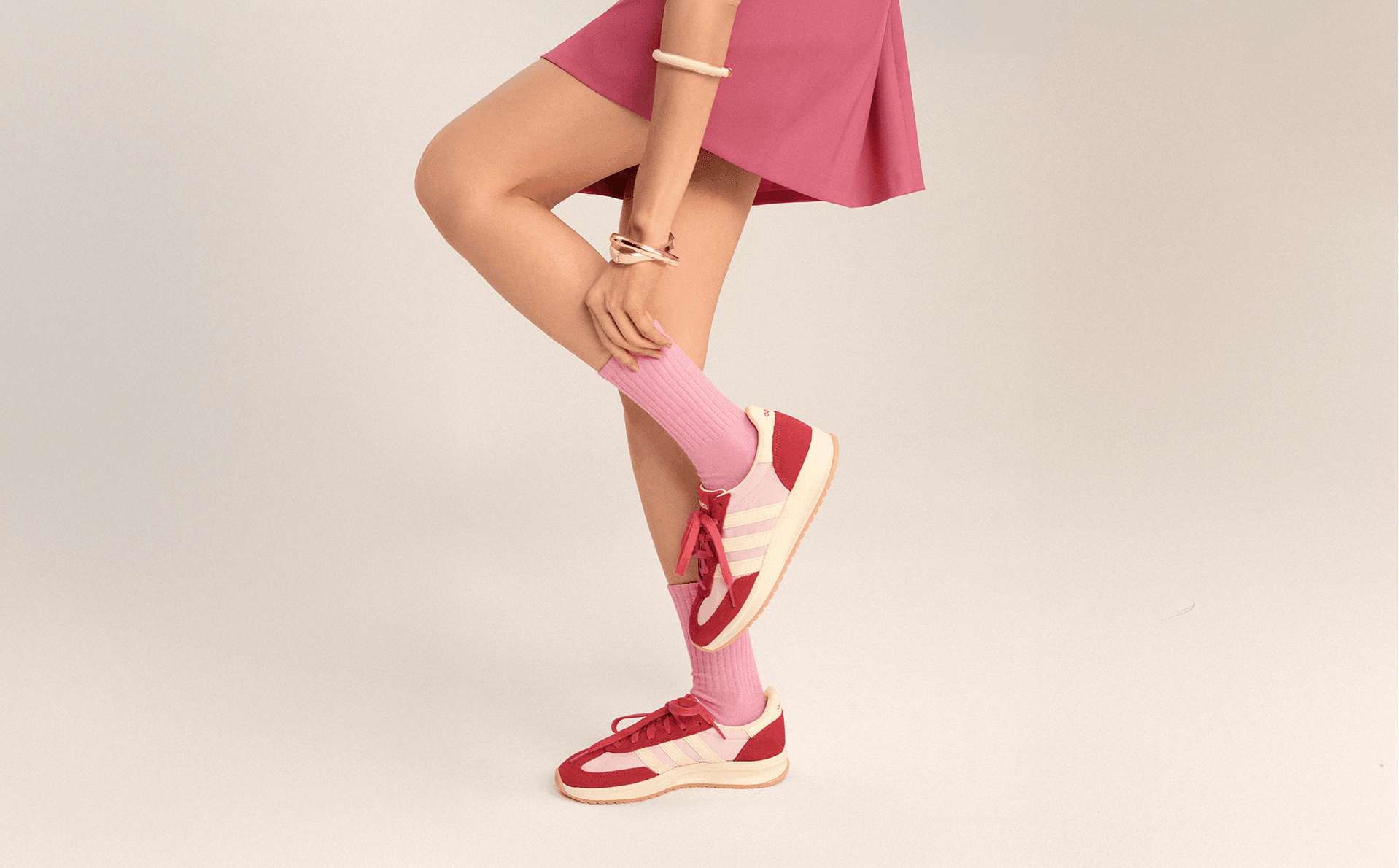 Model in a pink skirt and red sneakers, first styling of the same scene