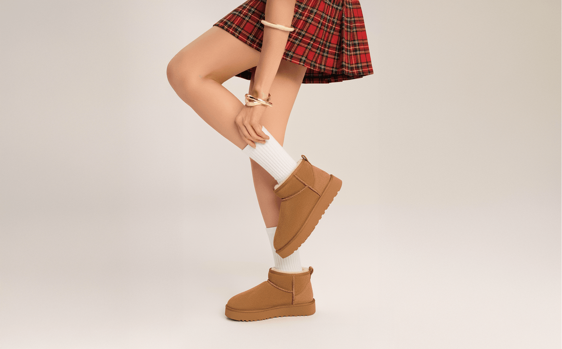 Model in a plaid skirt and suede boots, second styling of the same scene